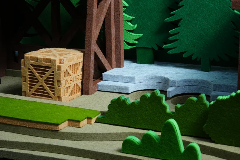 Crates, rocks and layered greenery in a miniature woodland scene